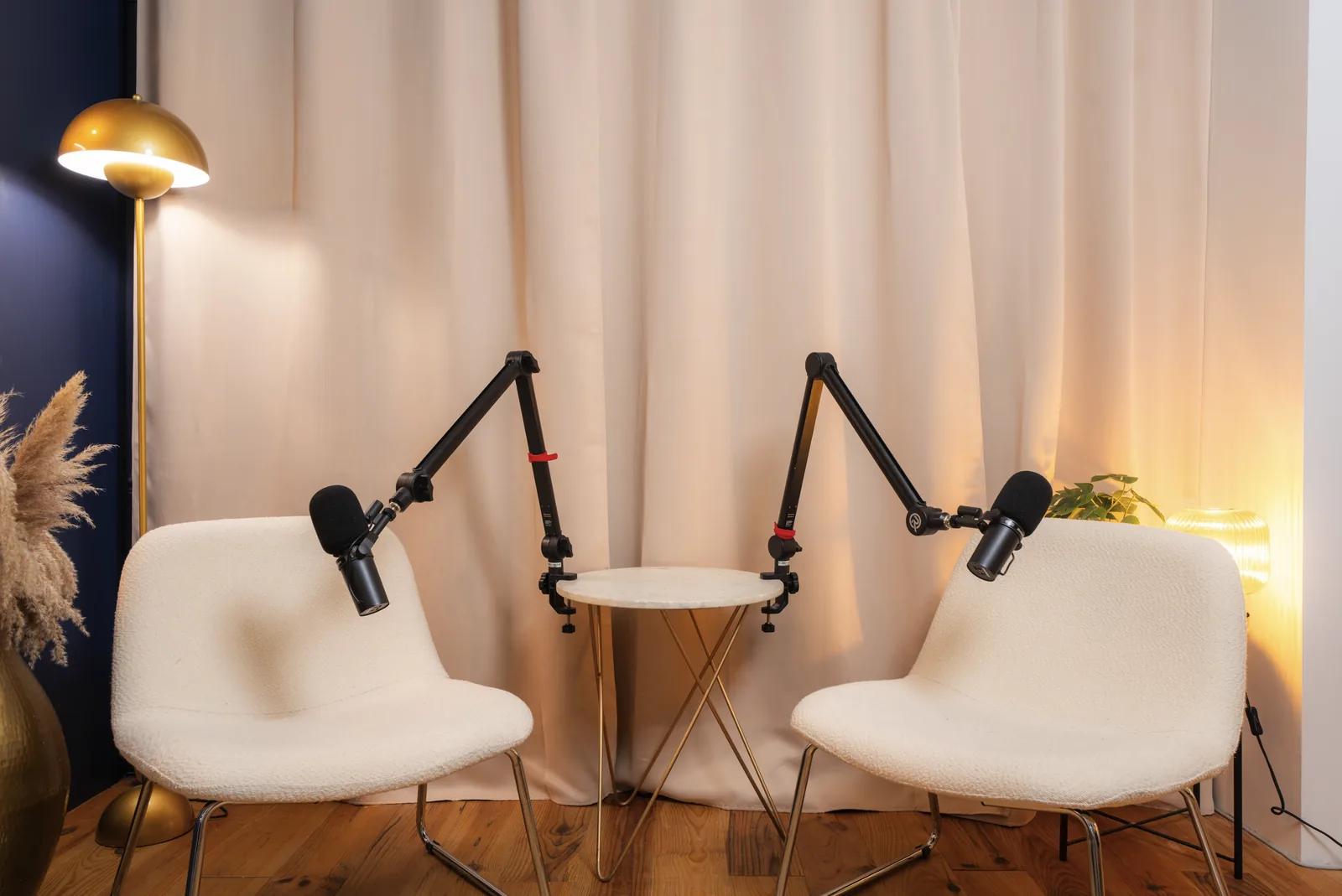 Décor Mercure du studio podcast KOSMOS à Bordeaux : rideau beige, lampe dorée et fauteuils blancs