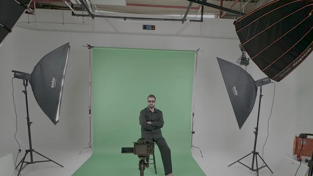 Film studio with a green screen, lights and a camera on a tripod